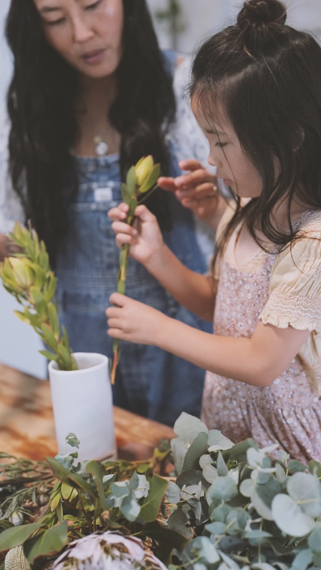 A little girl and her mom arranging flowers